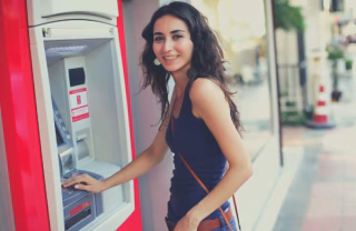 Young woman using an ATM Cardtronics ATM machine