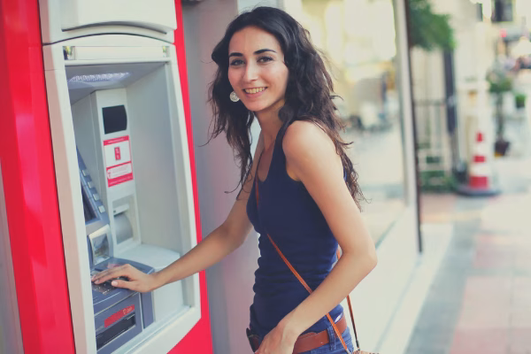 Young woman using an ATM Cardtronics ATM machine
