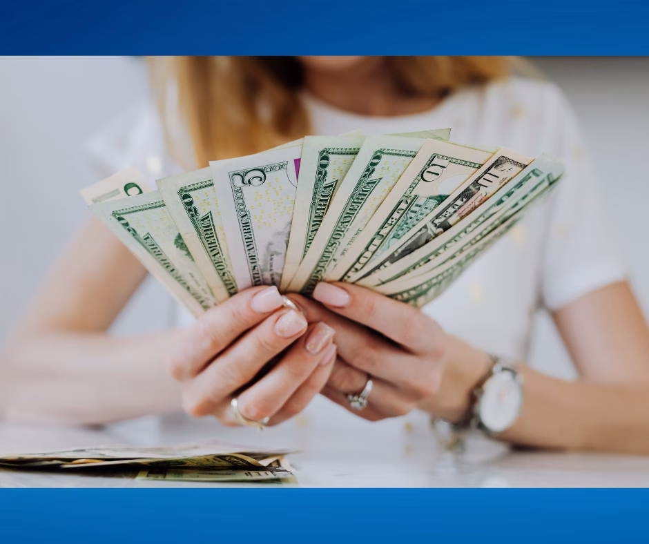 young woman's hands holding a lot of dollar bills