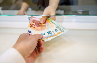 Hand of person handing money to another person